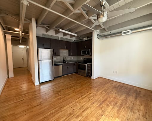 A kitchen with wooden floors and a refrigerator.