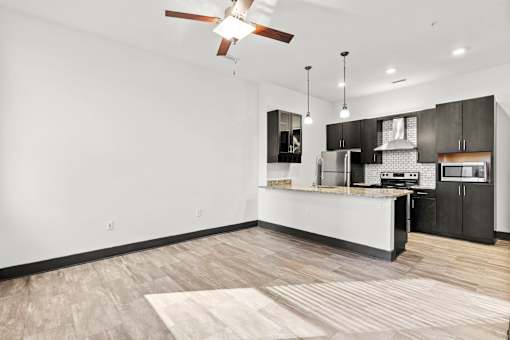 A modern kitchen with a white island and black cabinets.