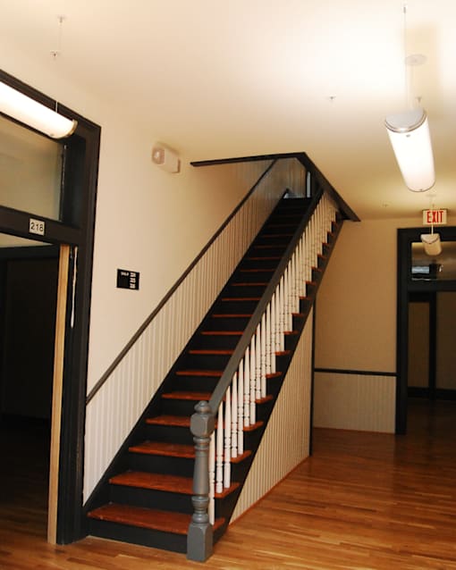 A staircase with a black railing and wooden steps.