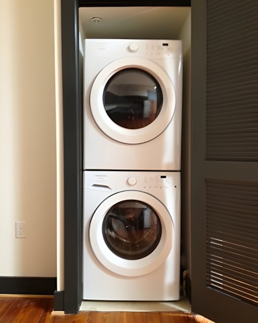 A white front load washing machine is installed in a wall.