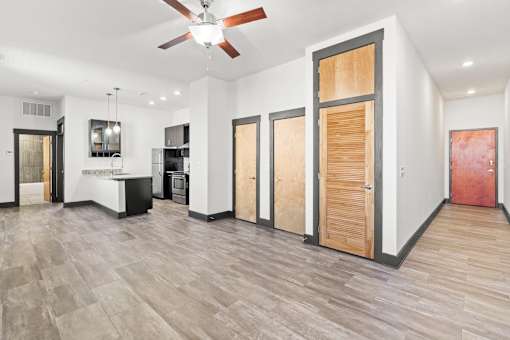 A room with a ceiling fan and wooden flooring.