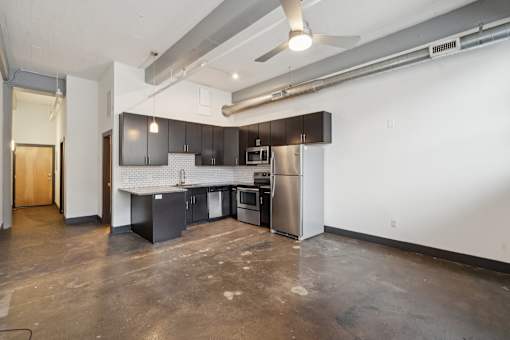 A kitchen with a refrigerator, microwave, and oven.