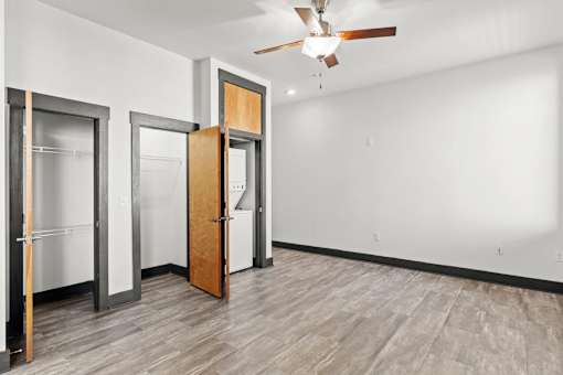 A room with a ceiling fan and a door.