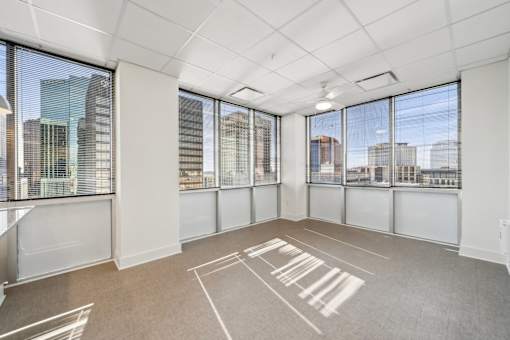 A spacious room with large windows overlooking a cityscape.