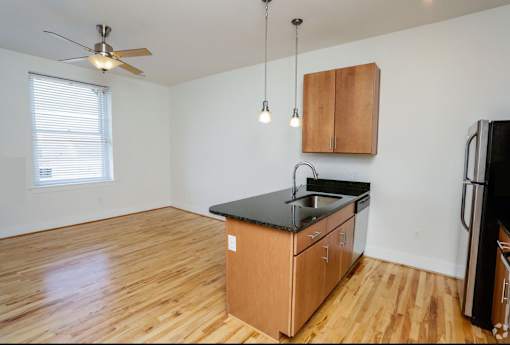 A kitchen with wooden floors and a black countertop.
