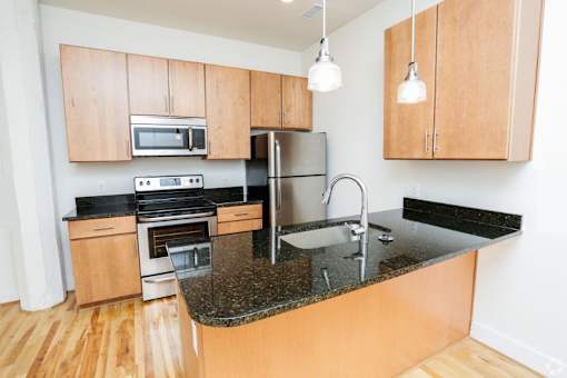 A kitchen with wooden cabinets and a granite countertop.