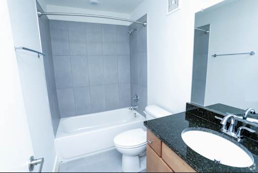 A white toilet sits next to a white bathtub in a bathroom.