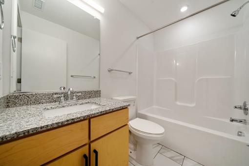 A white bathroom with a sink, toilet, and bathtub.