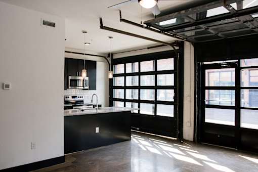 A kitchen with black cabinets and a large window.