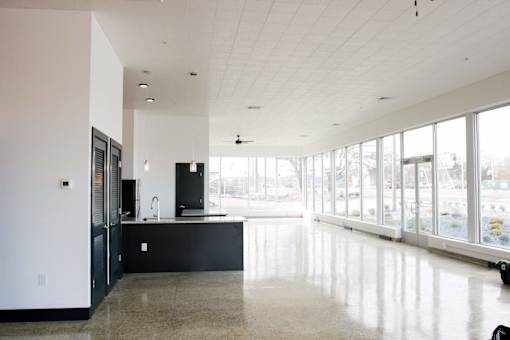 A kitchen with black cabinets and a large island with a sink.