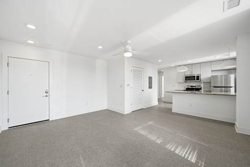 A large, empty room with a carpeted floor and white walls.