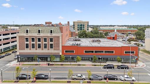 A parking lot with cars and a building in the background.