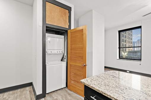 A kitchen with a white fridge and a wooden door.