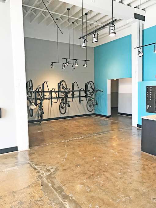 A room with a blue wall and a bicycle rack.