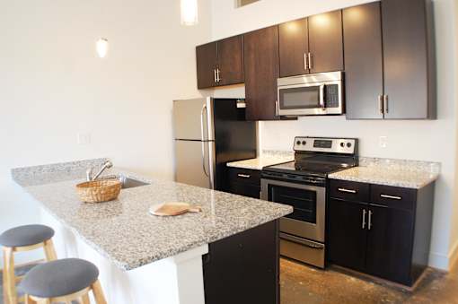 A kitchen with granite countertops and stainless steel appliances.