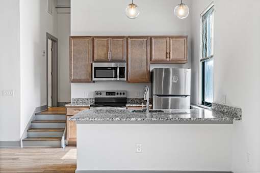 A kitchen with a stainless steel refrigerator, microwave, and oven.