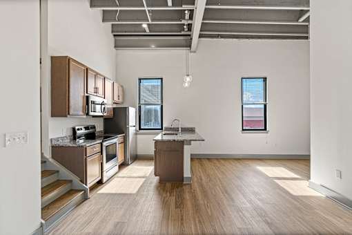A kitchen with wooden floors and a large island in the middle.