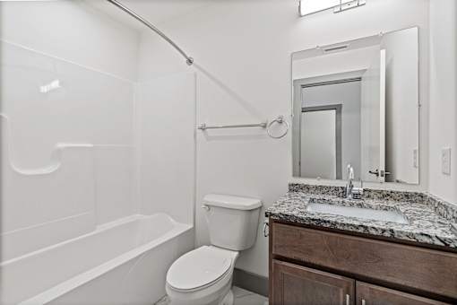 A white bathroom with a toilet, sink, and bathtub.