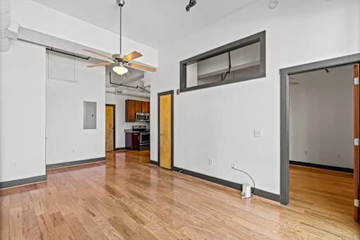 A room with a ceiling fan and a large mirror on the wall.