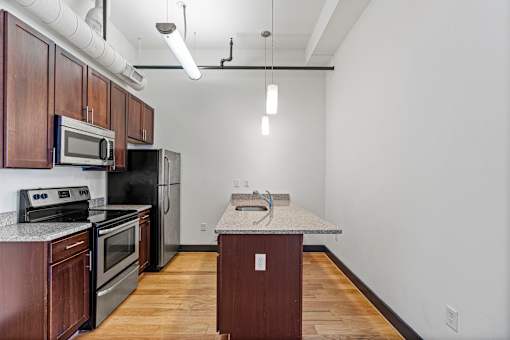 A kitchen with dark wood cabinets and stainless steel appliances.