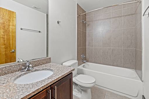 A bathroom with a white tub, sink, and toilet.