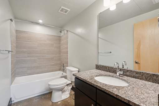 A bathroom with a white toilet and a white bathtub.