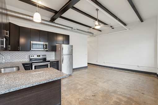 A kitchen with a refrigerator, oven, and sink.