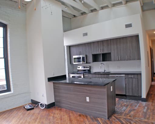 A kitchen island with a black countertop and wooden cabinets.