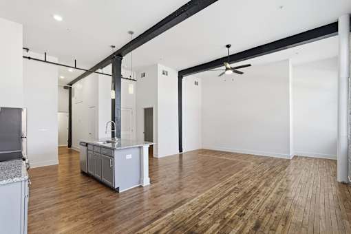A kitchen with a wooden floor and white walls.