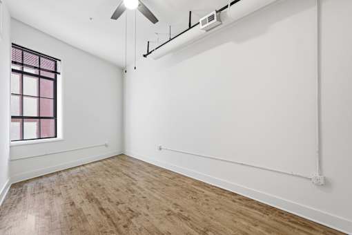A room with a window and a ceiling fan.