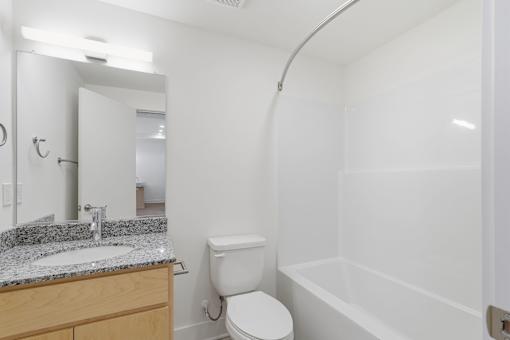 A white toilet sits next to a sink in a bathroom.