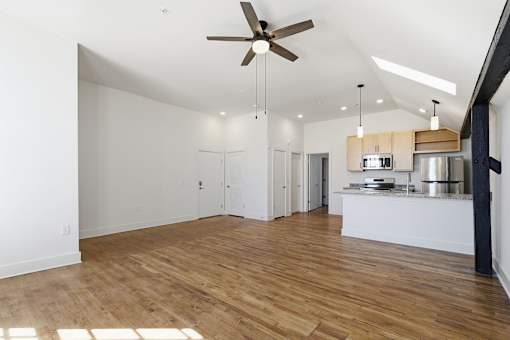 A room with a ceiling fan and wooden floors.