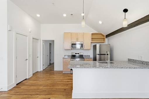 A kitchen with a refrigerator, microwave, and oven.