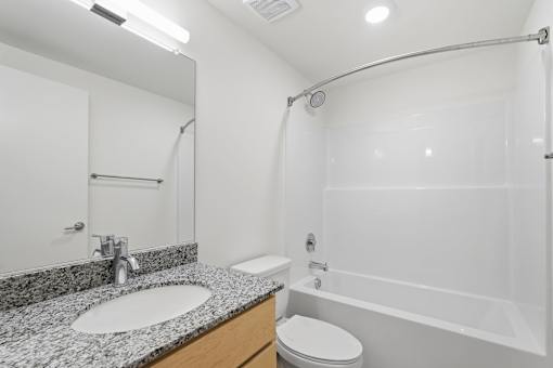 A bathroom with a sink, toilet, and bathtub.