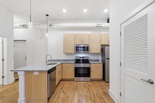 A kitchen with wooden cabinets and a granite countertop.