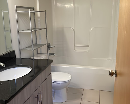 A white toilet sits in a bathroom next to a sink.