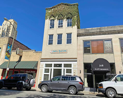A building with a green awning and a sign that says "Wellness" is in the background.