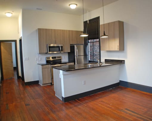 A kitchen with wooden floors and white walls.