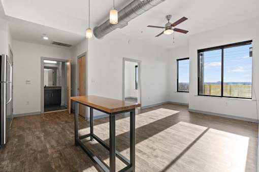 A spacious room with a table and a ceiling fan.