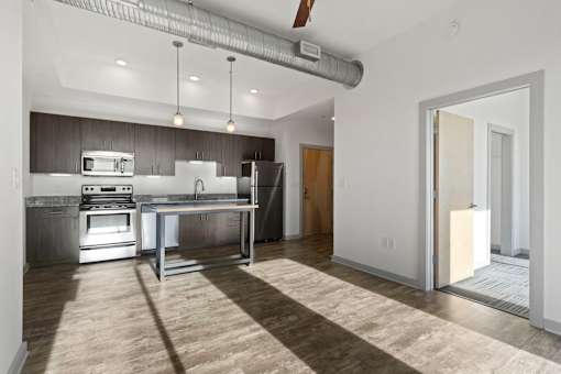 A modern kitchen with a large island and stainless steel appliances.
