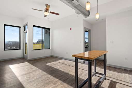 A room with a wooden table and a ceiling fan.