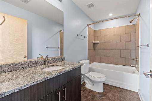 A bathroom with a sink, toilet, and bathtub.