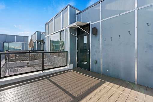 A modern building with a glass facade and a wooden deck.