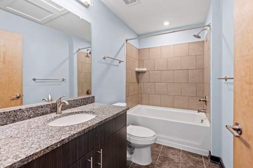 A bathroom with a white tub, sink, and toilet.