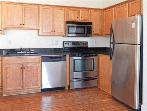 A kitchen with wooden cabinets and stainless steel appliances.