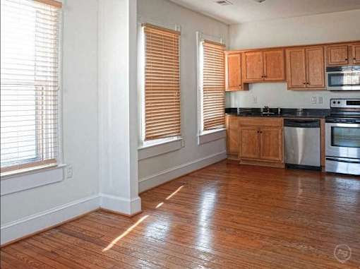 A kitchen with wooden floors and wooden cabinets.