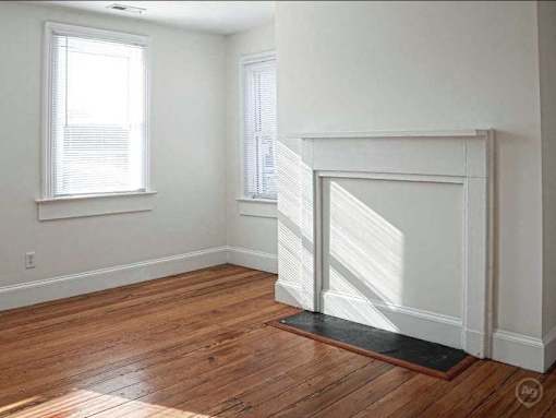 A room with a fireplace and a window.