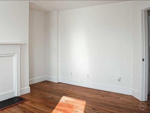A room with wooden floors and white walls.