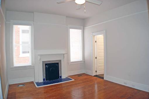 A room with a fireplace and a ceiling fan.