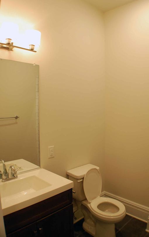 A white toilet sits next to a sink in a bathroom.